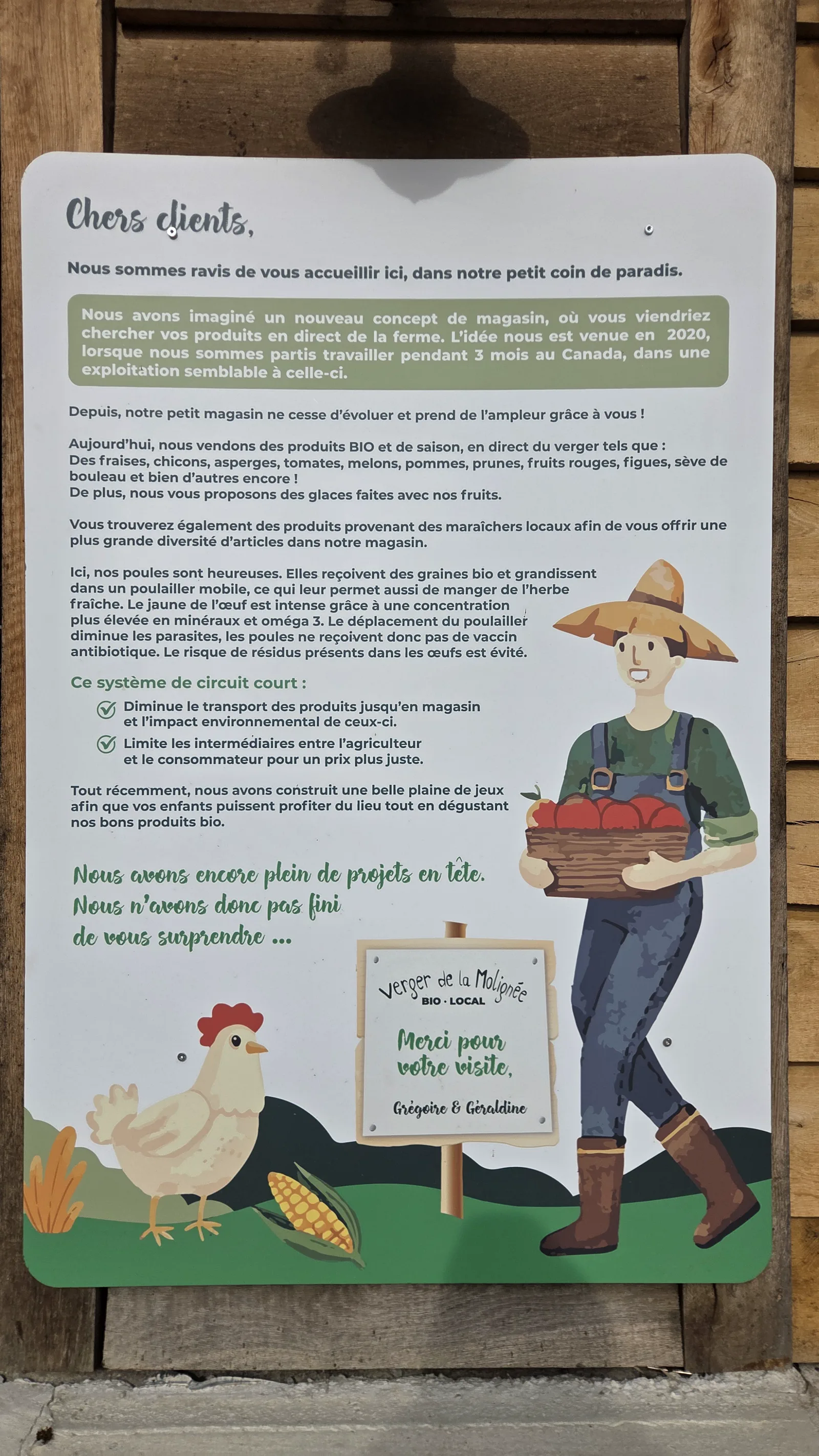 Panneau illustré affiché à l'accueil : une paysanne avec un panier de légumes, une poule, un épi de maïs, et un texte expliquant l'installation en 2020, le circuit court et les projets à venir